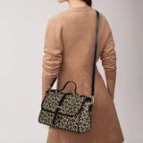 Leopard print satchel bag by Alternawear being worn by a model using the detachable cross body strap